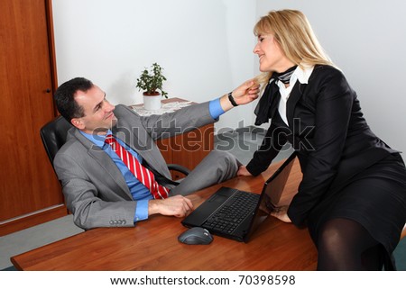 Businessman and businesswoman flirting in the office.