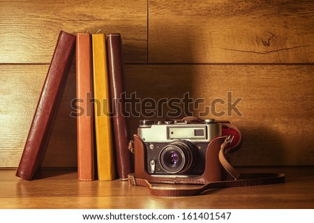 Vintage film camera with a leather case and a few books