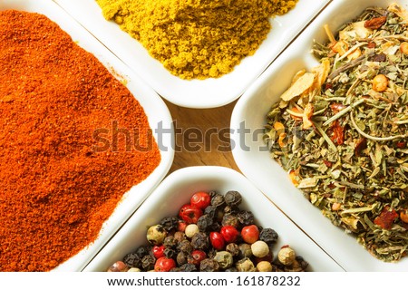 Red ground pepper, black pepper, curry powder and herb spices in bowls