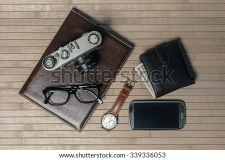 Men's accessories, wrist watch, glasses, leather book, smart phone, vintage camera, wallet, bamboo background