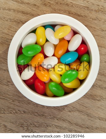 Jelly beans in round box on wooden table
