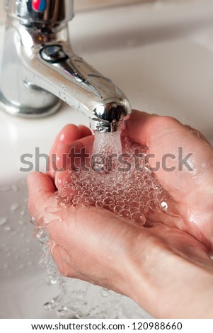 Washing hands under water tap