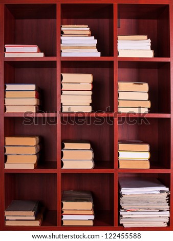 Books and magazines on a brown shelf