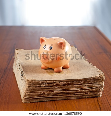 Piggy bank on an old book on a table