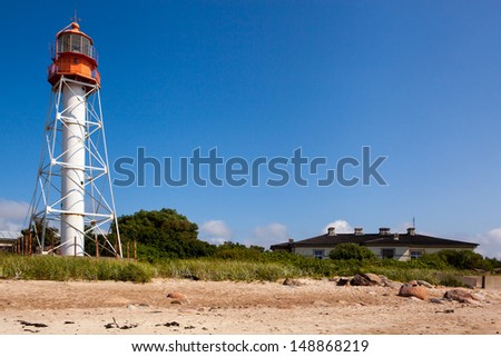 Lighthouse next to a house on the sea shore