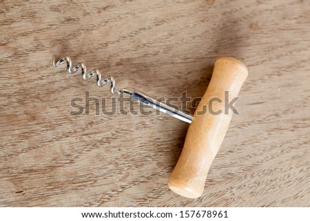 Wine bottle opener corkscrew with a wooden handle on a brown table