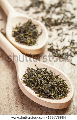 Wooden spoons with green tea herbs. Shallow DOF