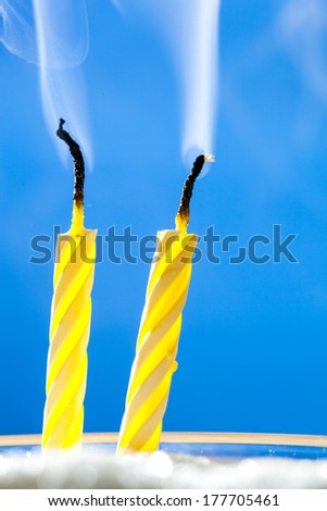 Two extinct birthday candles over blue background