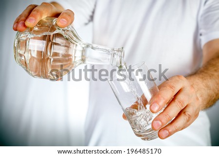 Carafe pouring water in glass