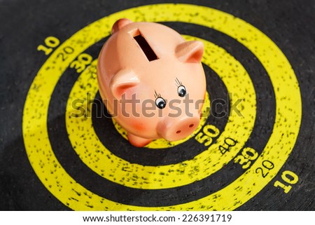 Saving concept: piggy bank on old yellow target board