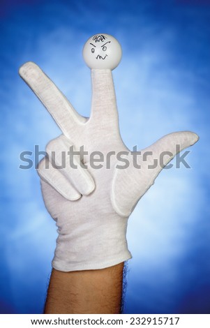 Angry finger puppet on white glove over blue background