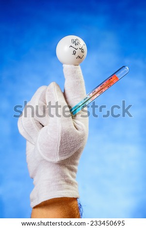 Concept of illness: finger puppet with medical thermometer showing forty degrees celsius
