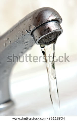 Water running from tap. Macro, shallow depth of field