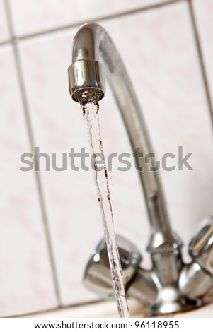 Water running from kitchen tap.  Shallow depth of field