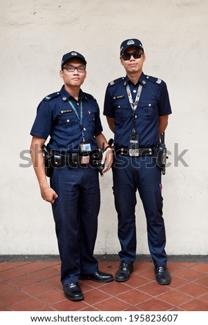 SINGAPORE - 10 FEBRUARY: Unidentified police on patrol in Little India on February 10, 2014 in Singapore. Singapore\'s crime rate hit a 30 year low in 2013 with total crime cases falling 4.3 per cent.