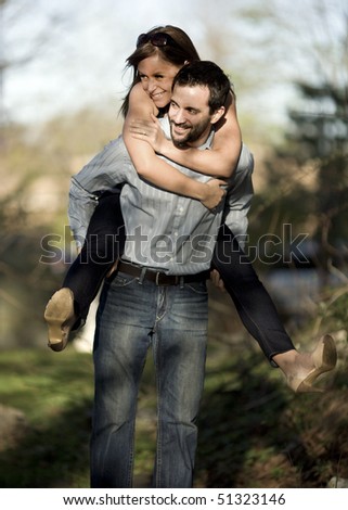 A young woman gets a piggyback ride from her male friend.
