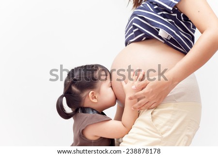 Girl is kissing  abdomen her mom