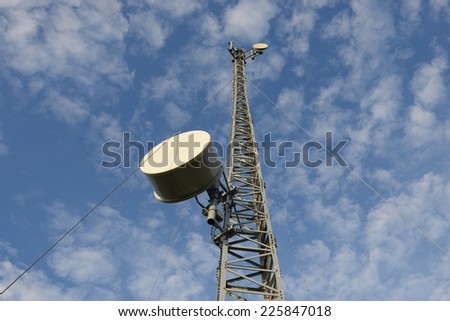 Mobile phone base station communications tower with blue sky