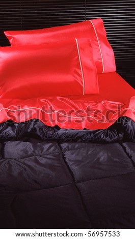 Black and red silk bed room set with black blinds in background