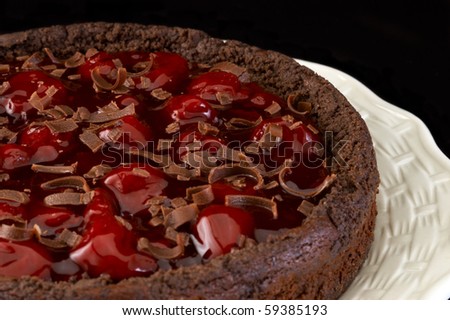Black forest strawberry cheese cake on white plate with black background