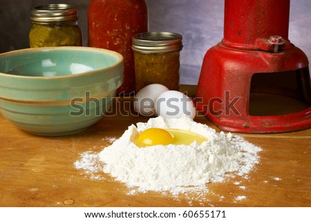 Egg in flour with bowl eggs waterpump and canned goods on counter