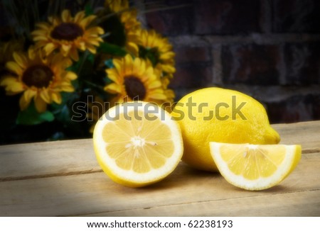 Lemons on table top with sunflowers and copy space SOFT FOCUS STUDIO SHOT