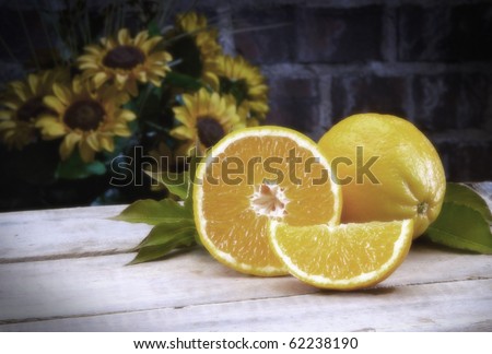 Vintage color Oranges on wood table top with sunflowers in background Studio Shot Soft focus