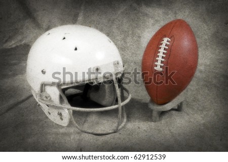 Football and helmet on tan studio background with copy space muted texture and tee SOFT FOCUS AND TEXTURE