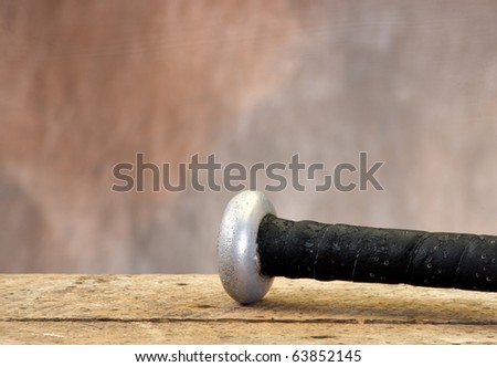 Baseball bat on old wood table and tan aged background with copy space