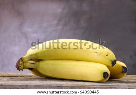 Bananas on and old vintage table top with modeled tan background for a rustic feel and copy space
