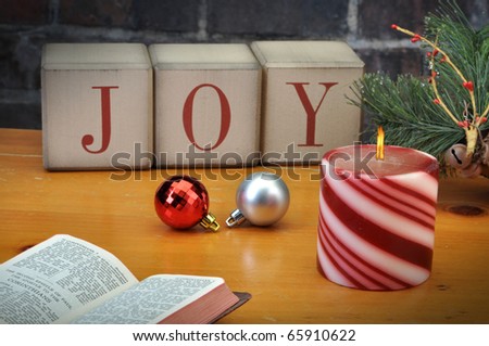 Old vintage holiday blocks spelling the word Joy with candle bible and ornaments