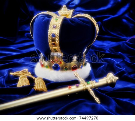 Beautiful crown and sword on royal blue fabric with soft window light and copy space