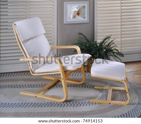 Lounge chair and foot rest with plant and window