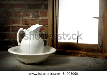 Vintage pitcher and washbasin on a rustic old wood set with window. Window is knocked out for your favorite image.
