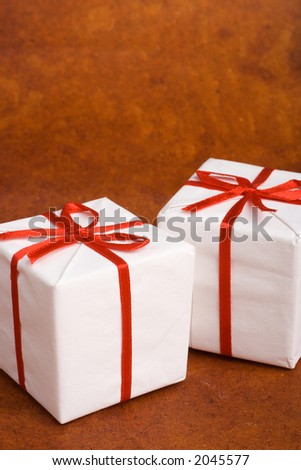 Two white Christmas or birthday gift boxes with red ribbon