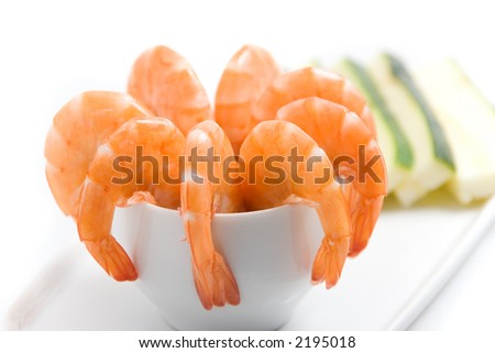 Closeup shot of an appetizer platter, with shrimps in a cup garnished with sliced zucchinis (shallow DOF)