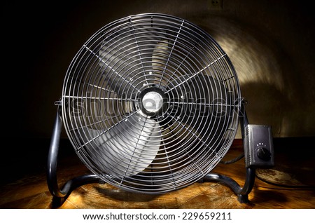 Black industrial electric fan with grid