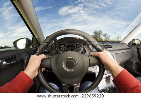Driver\'s hands on steering wheel of car