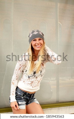 Smiling pretty young blonde woman candid portrait on city street
