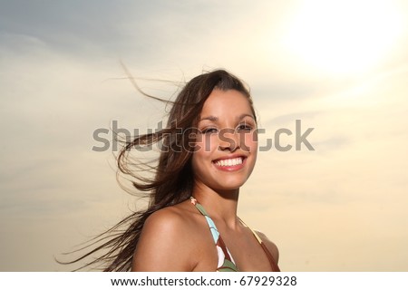 Young latina woman at the beach with sunset background