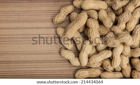 peanuts in shells over wood background