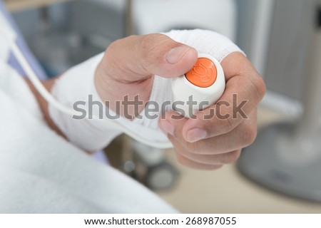Hand pressing emergency nurse call button