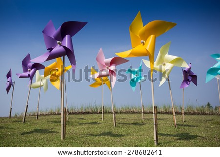 Toy windmill concept of green energy wind farm in field
