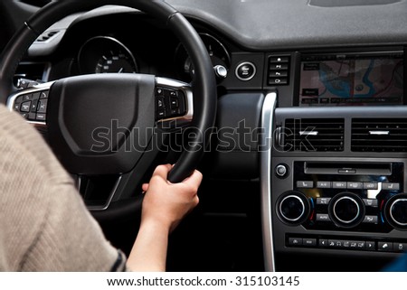 Hands on steering wheel in car interior