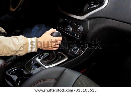 Driver man hand holding automatic transmission in car