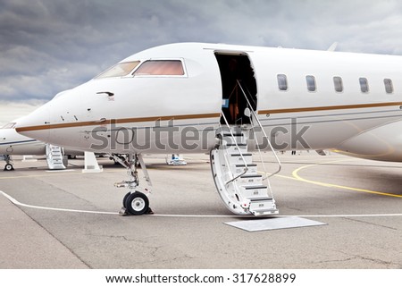 White private business jet and open ladder at the airport