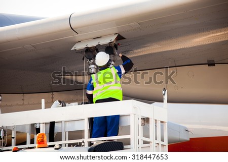 Airport worker refuelling the aircraft