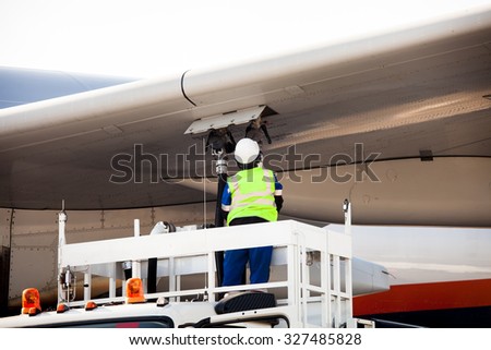 Airport worker refueling the aircraft
