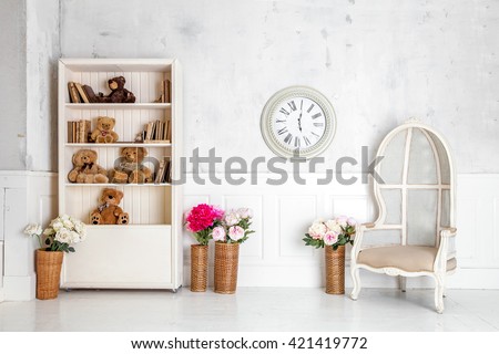 Modern light room interior with wardrobe, armchair and clocks on the wall. Kids room interior