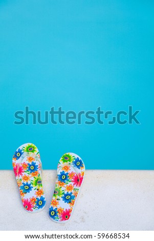 flip-flops with flowers near the swimming-pool